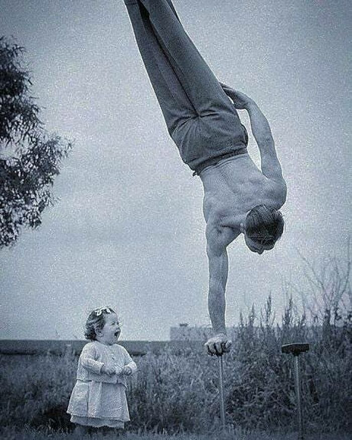 14. A mesmerized girl observes her father executing acrobatic maneuvers