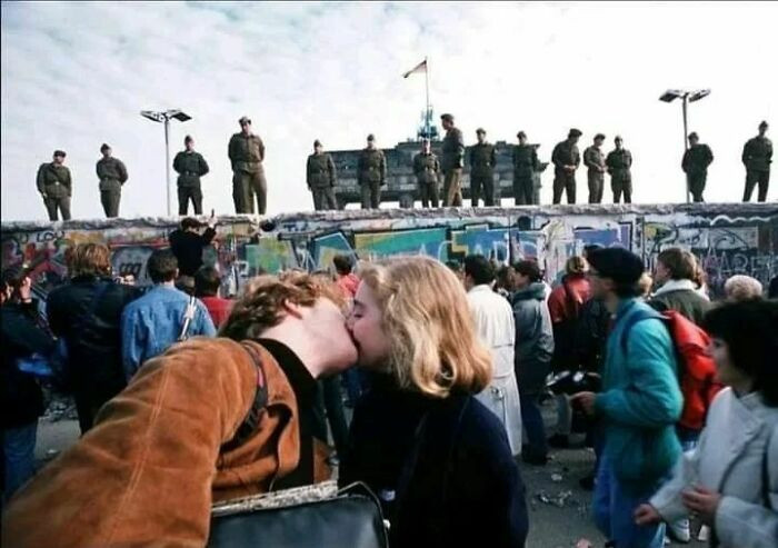38. In 1989, a poignant moment unfolded as a young couple shared a kiss just prior to the historic collapse of the Berlin Wall