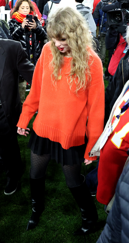 Tay-Tay paired the red sweater with black leather pants, Larroudé boots, a dark jacket, and gold jewelry.