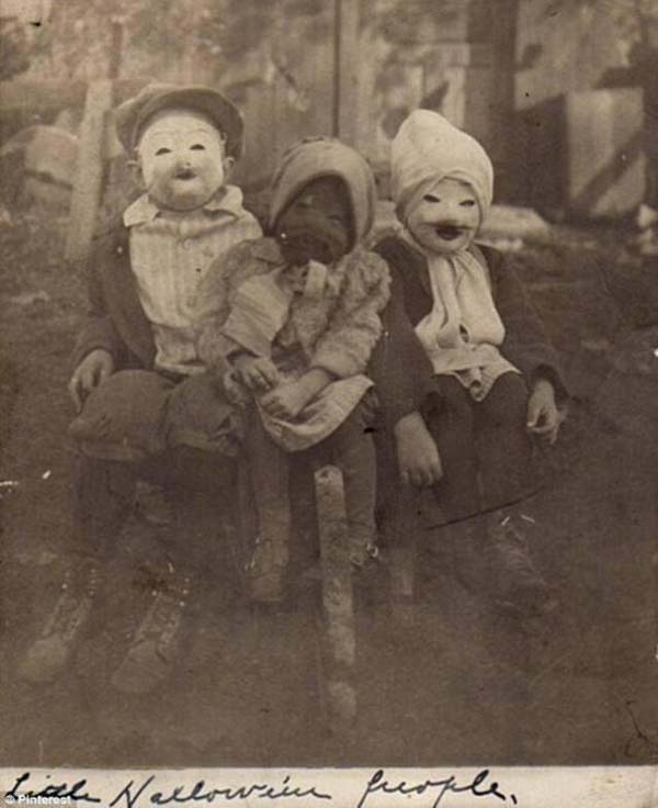 8. Three kids and their spooky “Halloween people” costumes (1900).