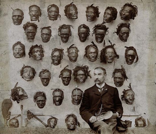 17. A man proudly sits with his severed head collection